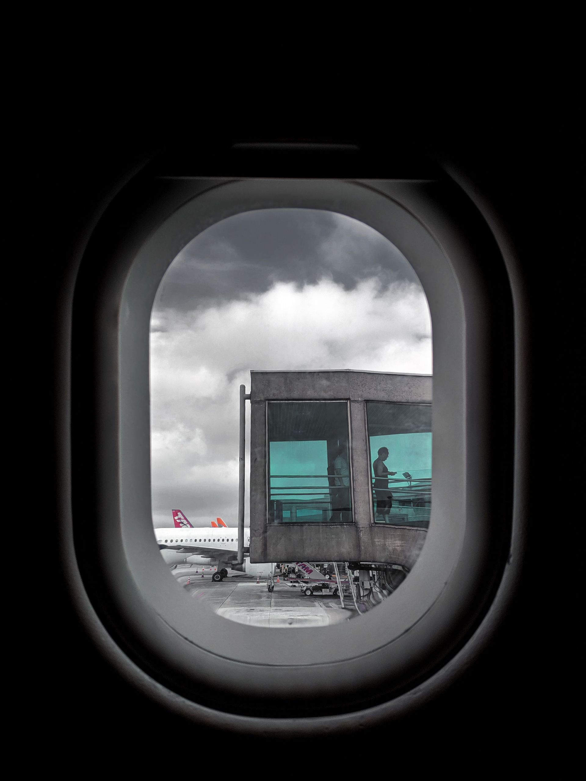 A unique view of São Paulo airport through an airplane window on a cloudy day.