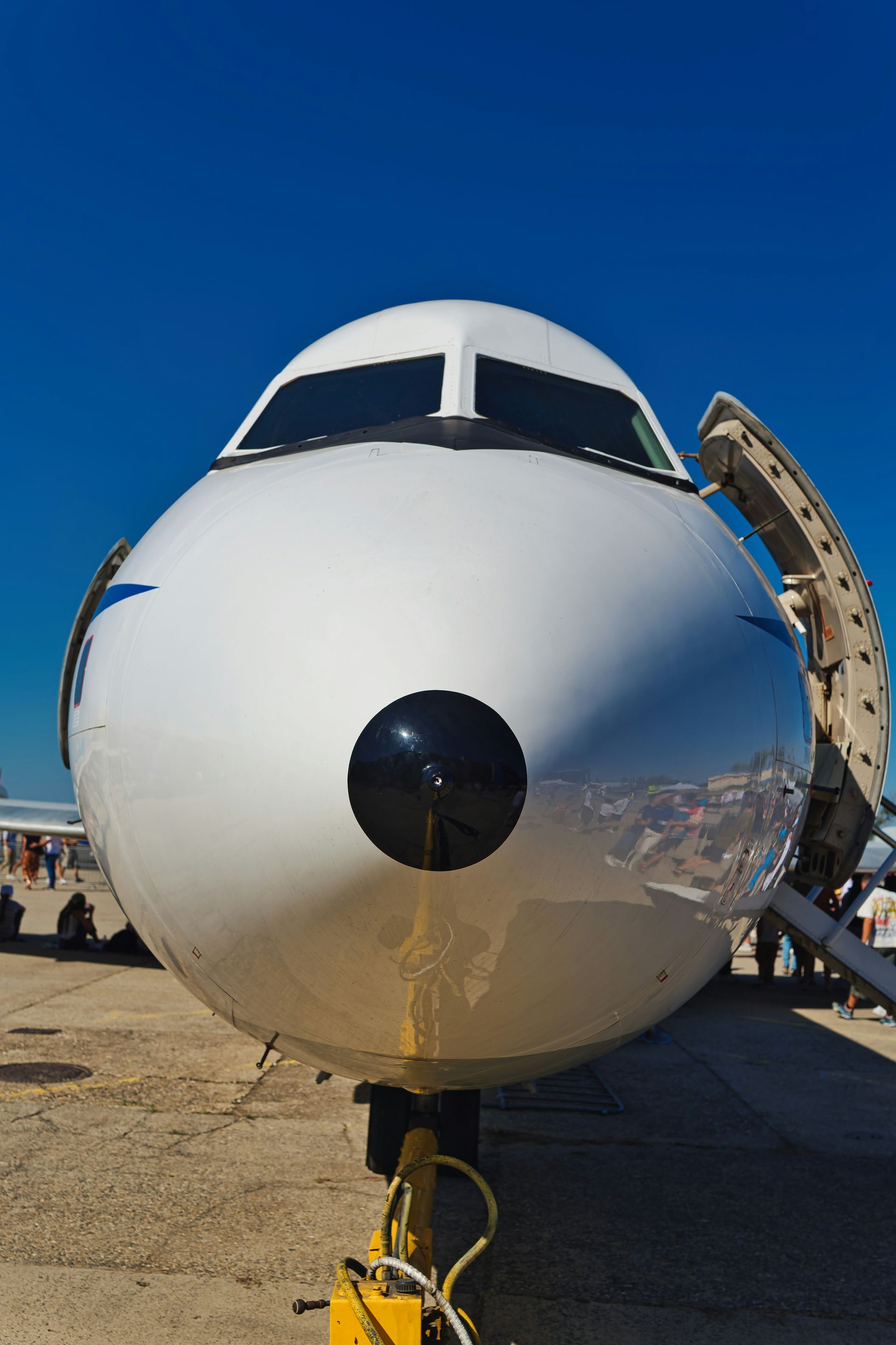 Front view of a white airplane with open door.